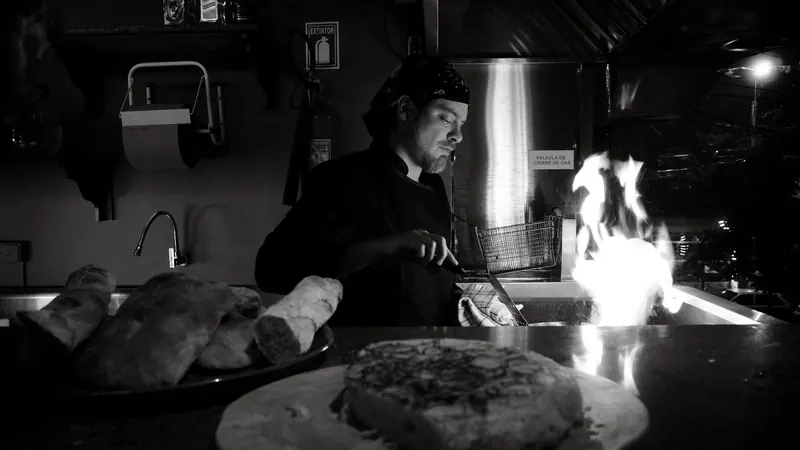 A chef cooking over a gas flame in a restaurant kitchen